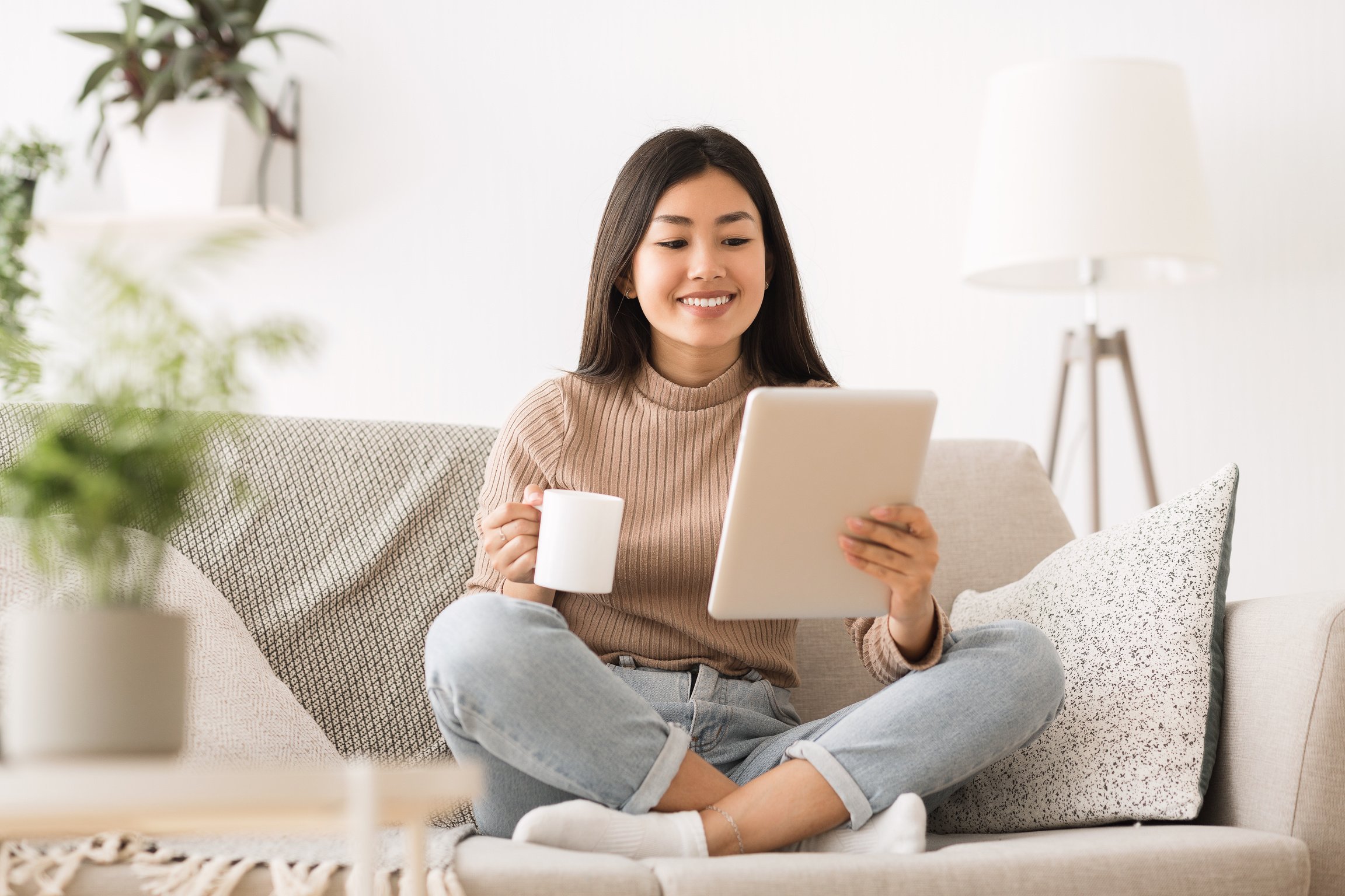 Cheerful girl reading e-book on digital tablet